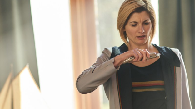 Jodie Whittaker as the Doctor reading information from off of her sonic screwdriver